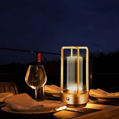 Gold rechargeable cordless table lamp on an evening dining table